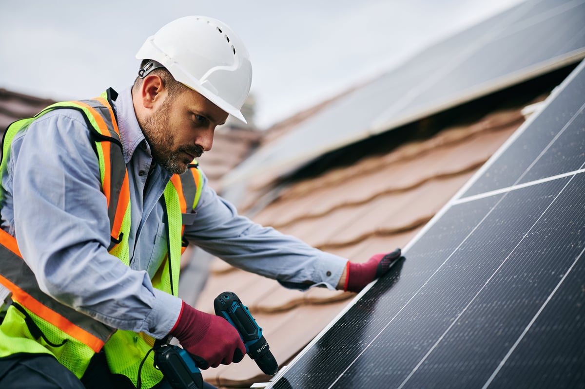 Engineer installing solar panels on a residential roof